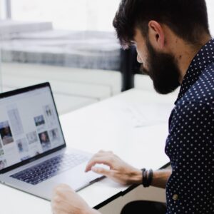 man looking at photos on laptop