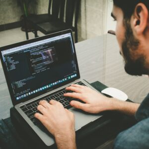 man typing code on MAcbook